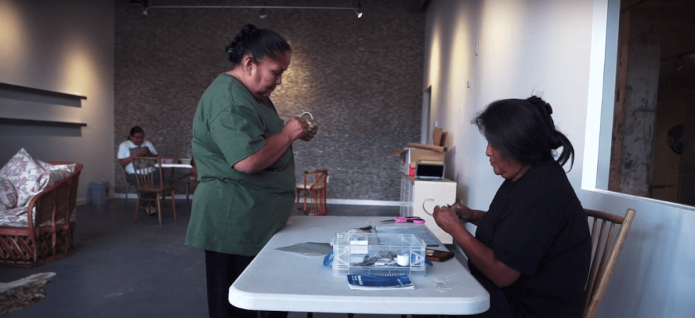 Two Native American women working on jewlery