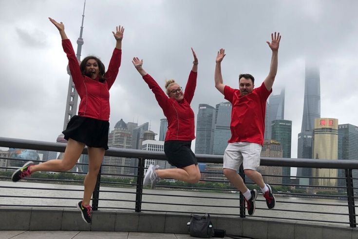 Rob DelCampo and two others jumping in front of the Shanghai skyline.